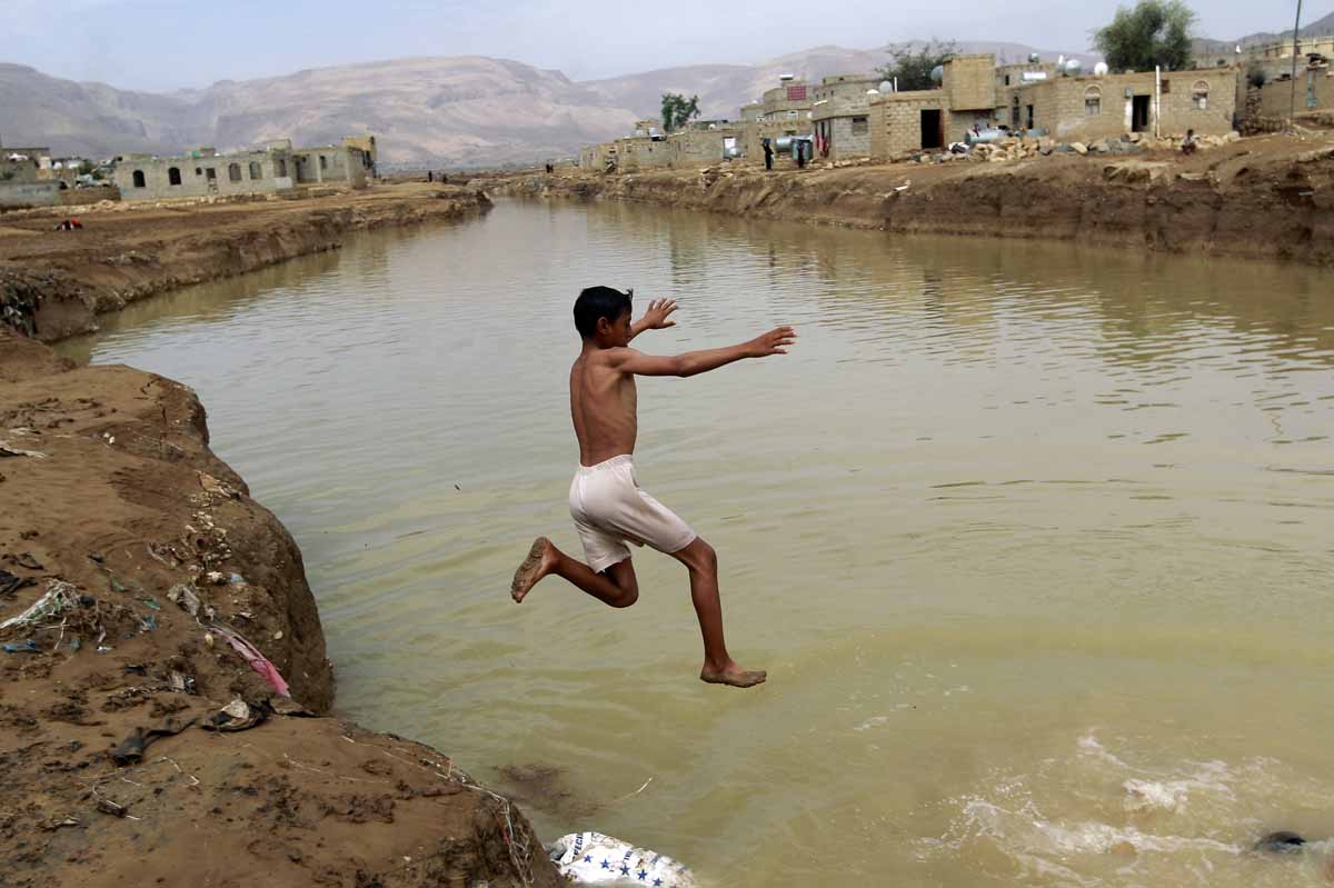 A Yemeni boy dives into a flooded field following heavy rain fall, in the city of Amran, 50 kms north of Sanaa, on April 15, 2016.
