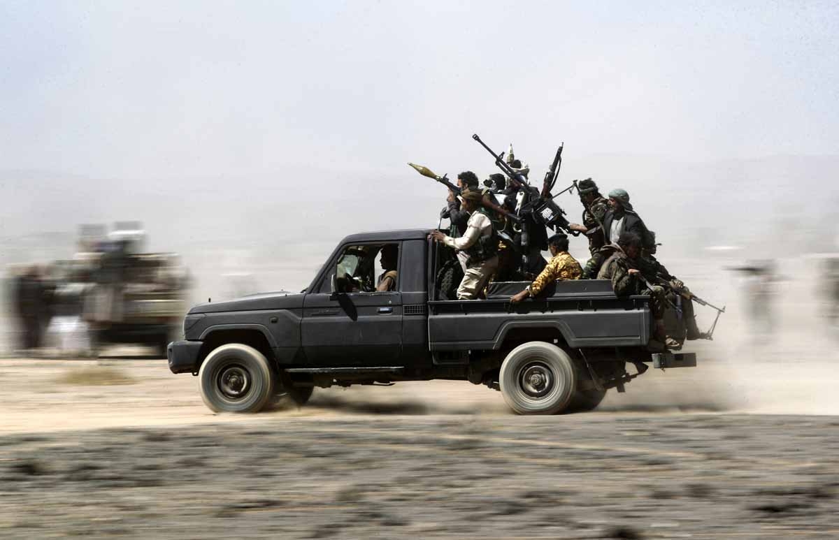 Armed Yemeni tribesmen loyal to the Shiite Huthi rebels sit in the back of an armed vehicle during a gathering to mobilise more fighters into several battlefronts on November 1, 2016 on the outskirts of the capital Sanaa. 